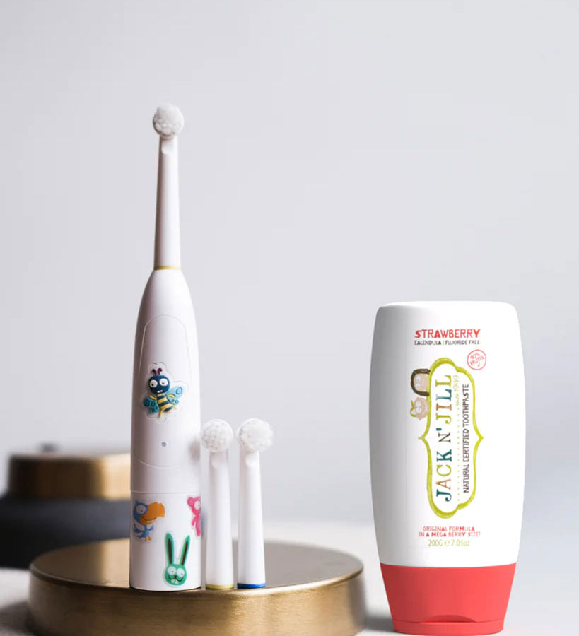 Jack N' Jill Fluoride-Free Strawberry Toothpaste 200g pictured next to buzzy brush toothbrush