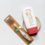 Jack N' Jill Fluoride-Free Strawberry Toothpaste 200g pictured next to toothbrush with monkey motif