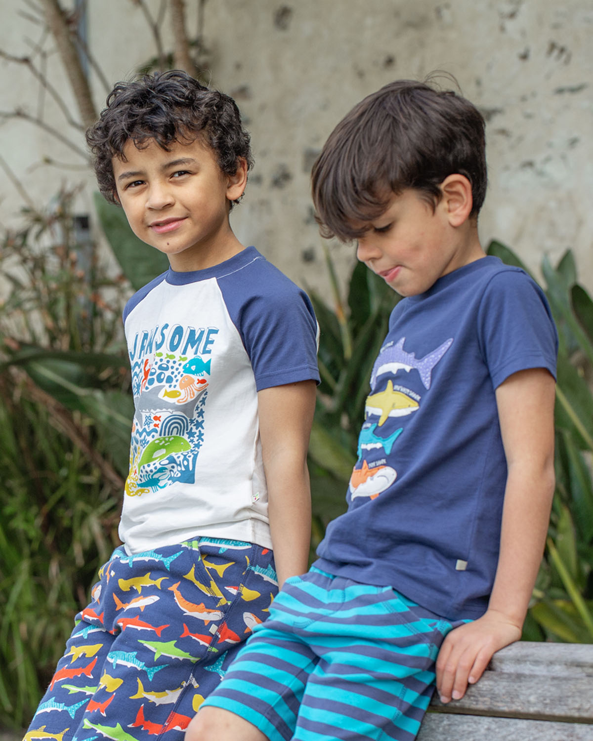 A close up of the Jawsome print of the Frugi Reid Raglan T-Shirt - Jawsome. A colourful t-shirt made from GOTS Organic cotton  with a white body with sea-life animal print