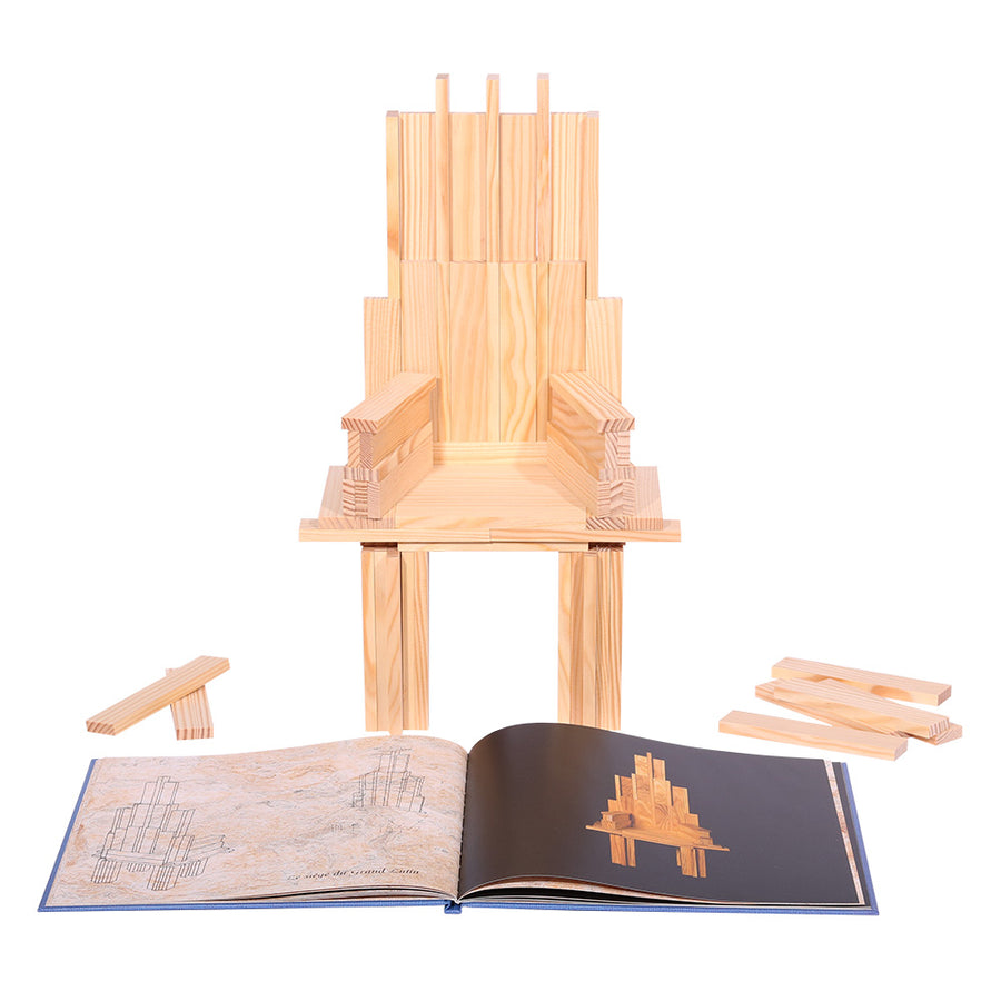 Kapla advanced art book open in front of a wooden model chair on a white background