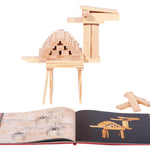 Kapla beginner art book open in front of a wooden camel model on a white background