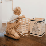 Child kneeling down making a wall with the Kapla plastic-free wooden building planks