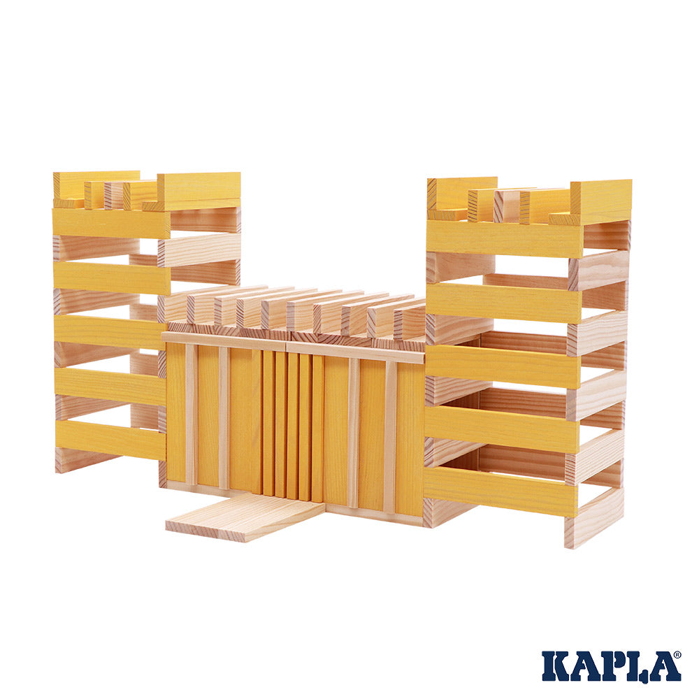 Kapla plastic-free wooden stacking blocks built up in a fort shape on a white background