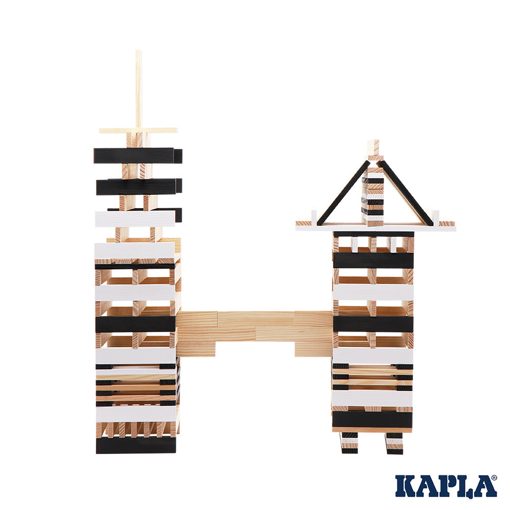 Kapla plastic-free black and white construction shapes stacked in two towers on a white background