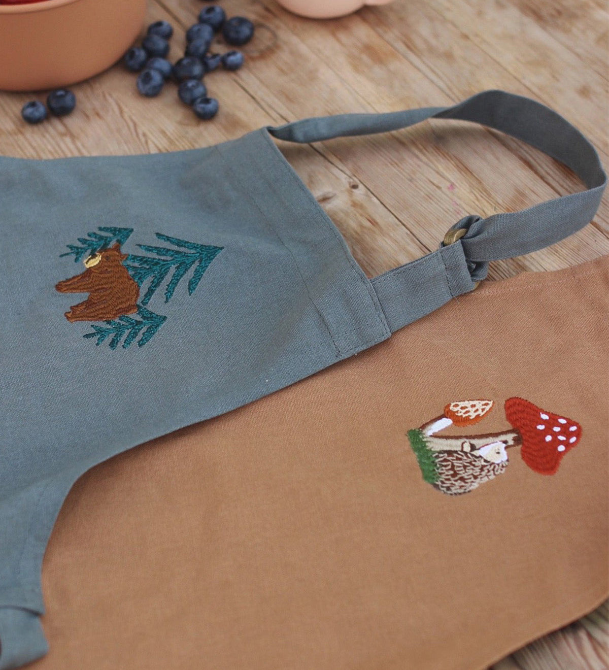 embroidered bear and tree pattern of the chest of the apron.