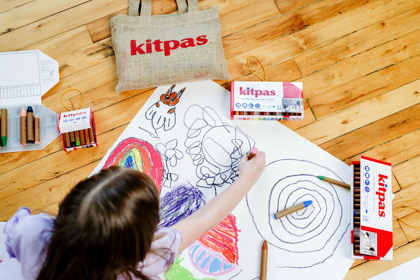 Two children drawing with the Kitpas non-toxic coloured crayons on a window