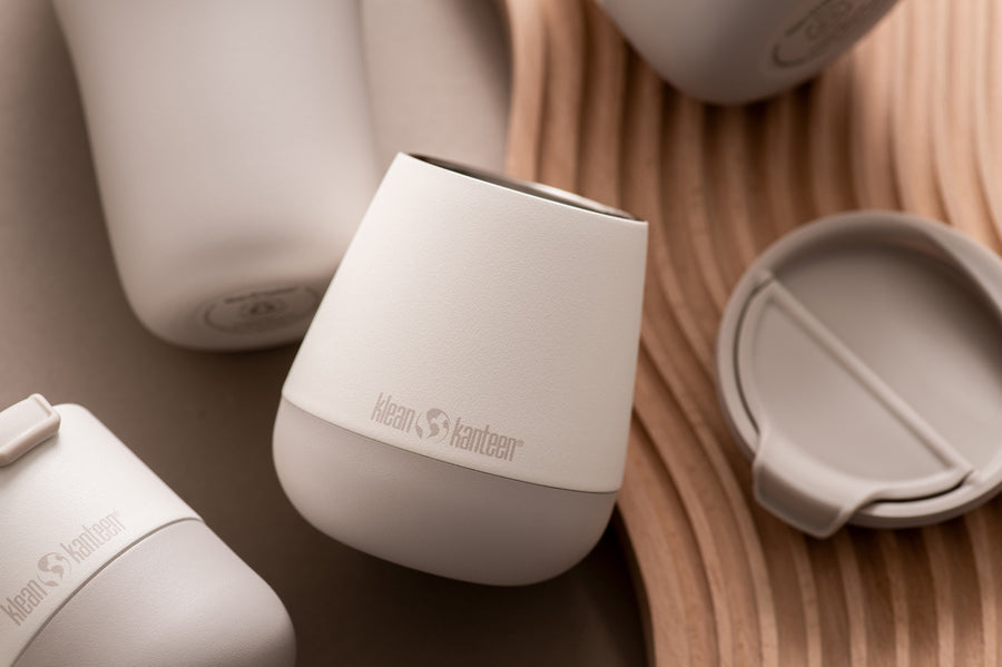 Close up of a Klean Kanteen plastic-free wine tumbler in the tofu beige colour on a curvy wooden board