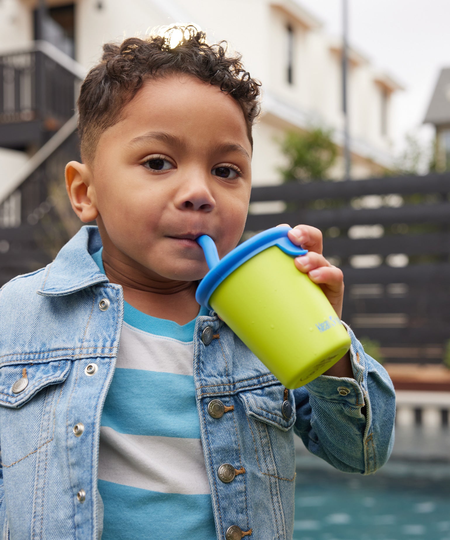 A child drinking out of a Klean Kanteen Steel Kid Cup with Straw Lid.