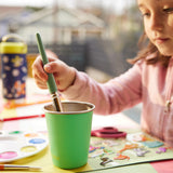 A child using a Klean Kanteen Steel Kid Cup to clean a paint brush. 