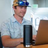 A person sitting at atable in front of a laptop with Klean Kanteen 12oz TKWide Cafe in the black colour placed in front of them.