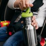 Close up of toddler in a car seat holding the Kid Kanteen 12oz stainless steel sippy bottle