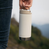 A close up of a person's hand carrying a Klean Kanteen 12oz TKWide Cafe in the tofu colour.