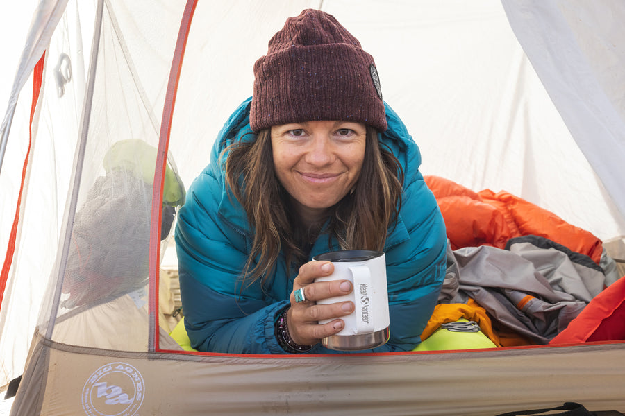 An adult enjoying a drink from their Klean Kanteen 12oz Insulated Camping Mug in White