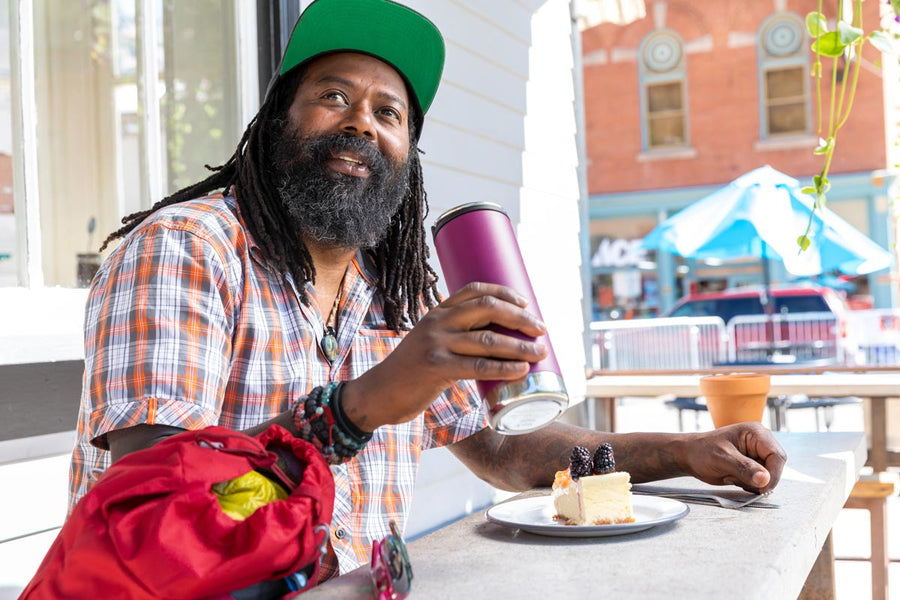 Man sat at a bench holding a Klean Kanteen eco-friendly stainless steel drinks bottle