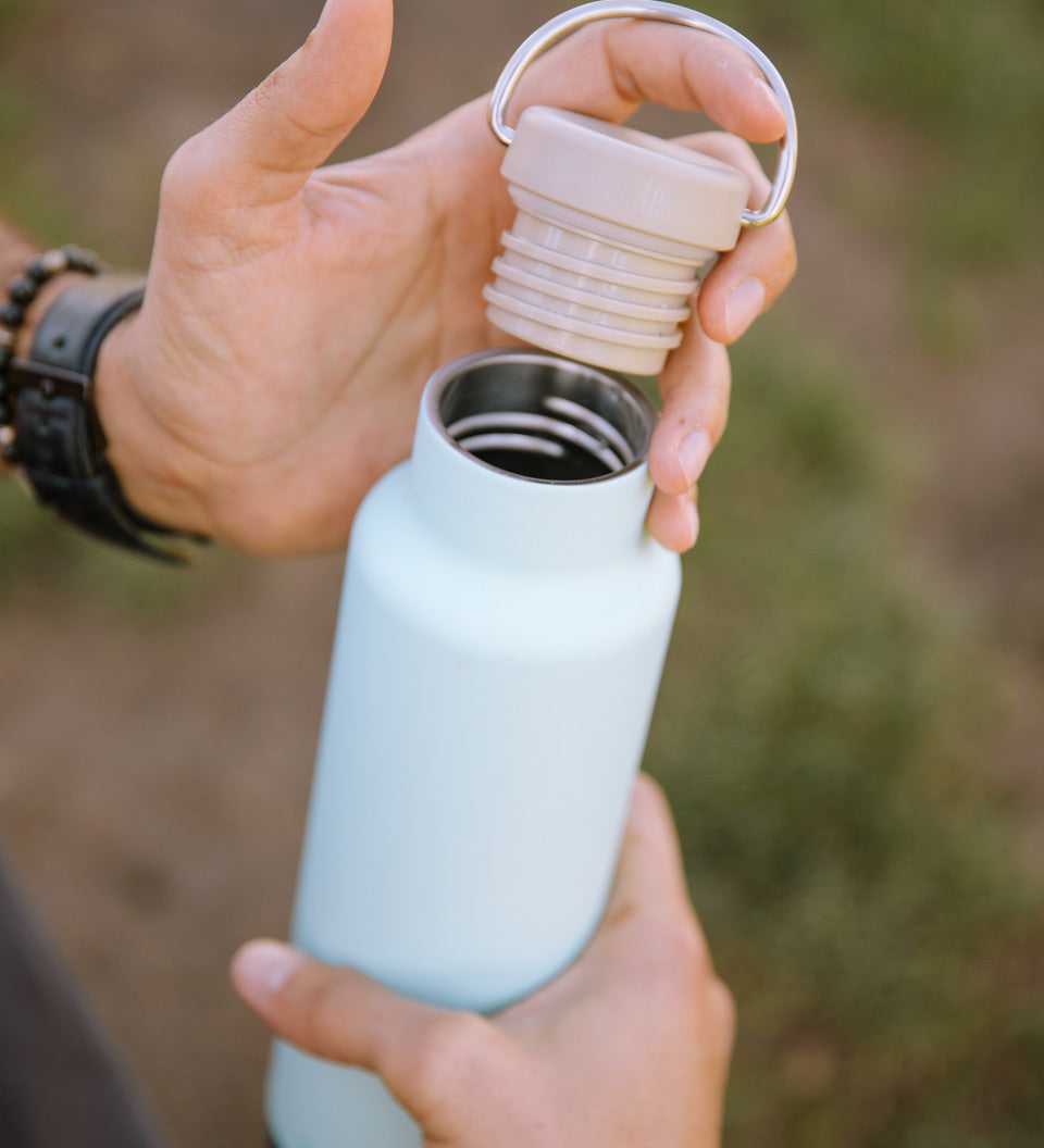 Close up of hands holding the Klean Kanteen 20oz insulated metal drinks bottle 