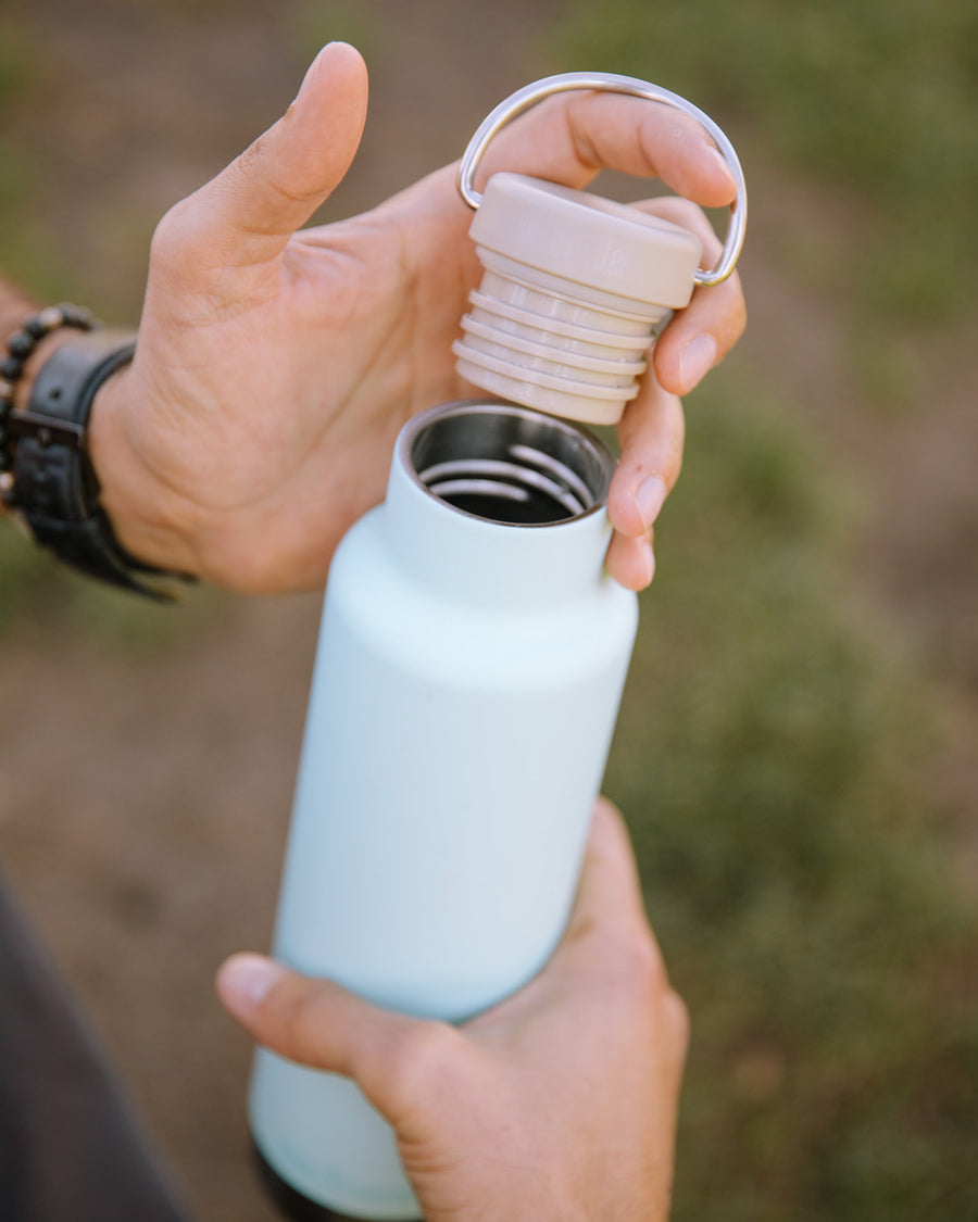 Close up of hands holding the Klean Kanteen 20oz insulated metal drinks bottle 