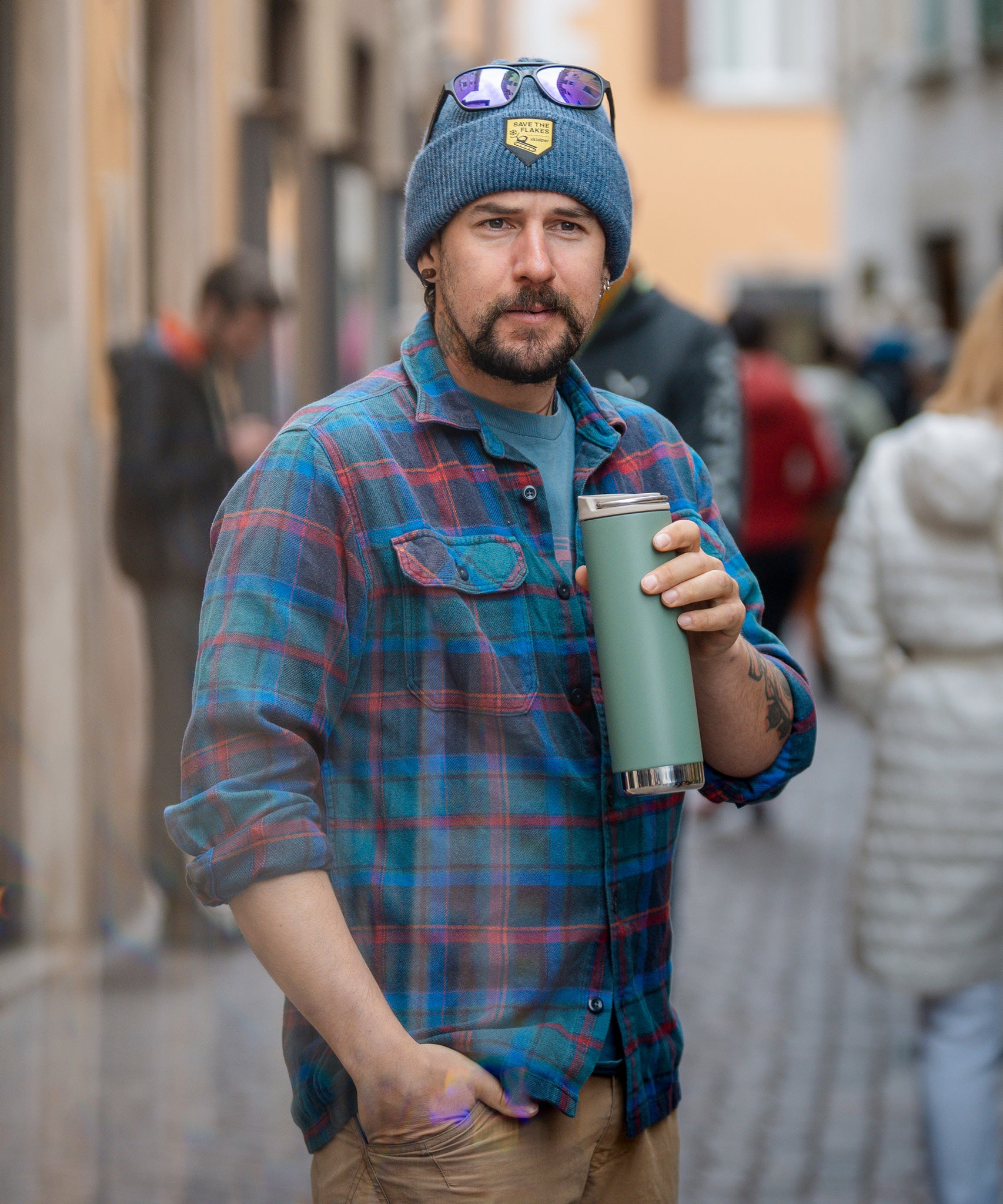 A man holding a sea spray green coloured Klean Kanteen 20oz TKWide Cafe. 