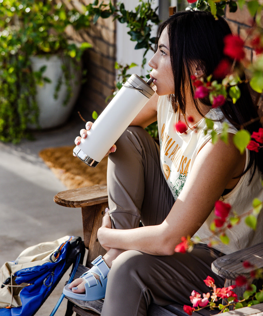 A person drinking from a tofu white coloured Klean Kanteen 20oz TKWide .