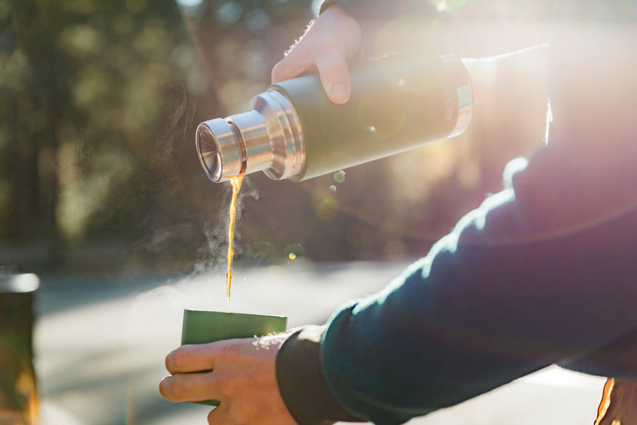 Close up of some hands pouring hot liquid into the cup of a Klean kanteen 25oz insulated tkpro flask