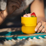 Close up of some hands scooping out some yoghurt from a Klean Kanteen insulated metal lowball glass on a blue blanket