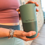 Close up of a woman holding a Klean Kanteen stainless steel tumbler in the Ocean Spray green colour