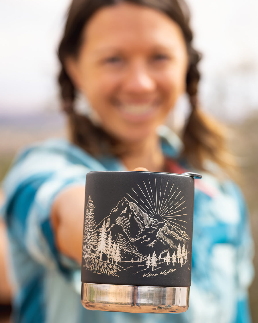 An adult holding the Klean Kanteen 12oz Insulated Mug in Black Mountain