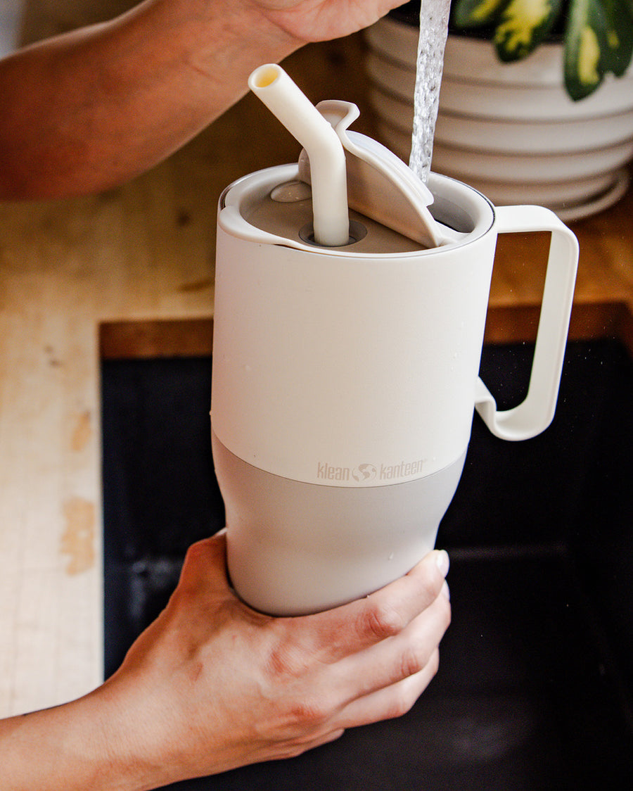 A close up of a person filling up a Tofu coloured Klean Kanteen Limited Edition 36oz Rise Tumbler with water from a tap