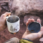 Close up of hands holding the Klean kanteen eco-friendly metal camp mug in the matte white mountain colour