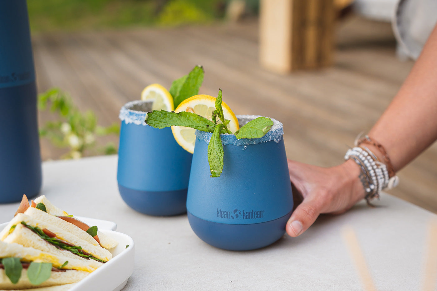 Close up of a hand holding a Klean Kanteen blue insulated wine tumbler