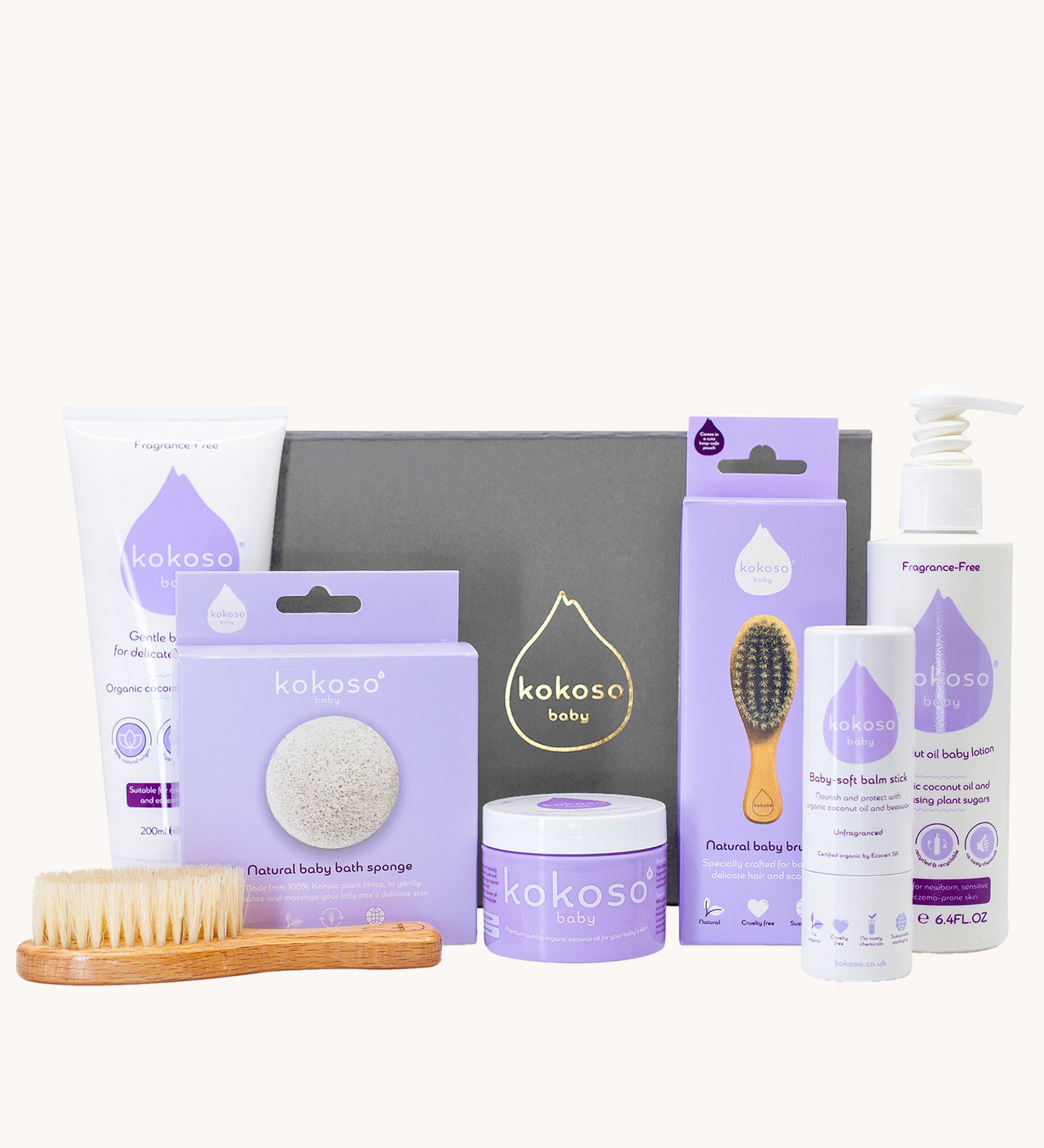 Kokoso Fragrance Free Collection Gift Set. Includes Baby Lotion, Baby-Soft Balm Stick, Natural Brush, Natural Sponge, Coconut Oil, Gentle Hair & Body Wash, on a cream background