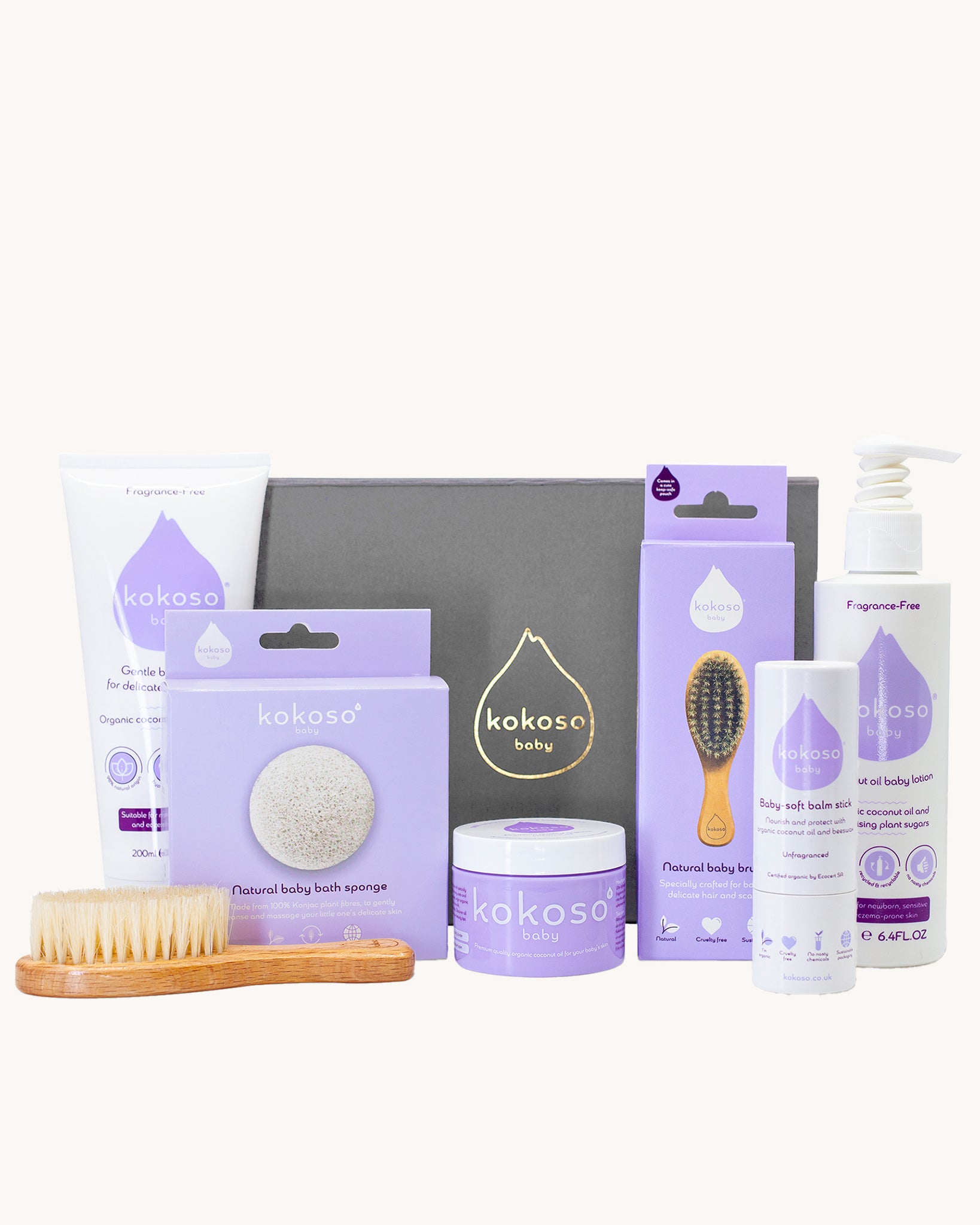 Kokoso Fragrance Free Collection Gift Set. Includes Baby Lotion, Baby-Soft Balm Stick, Natural Brush, Natural Sponge, Coconut Oil, Gentle Hair & Body Wash, on a cream background