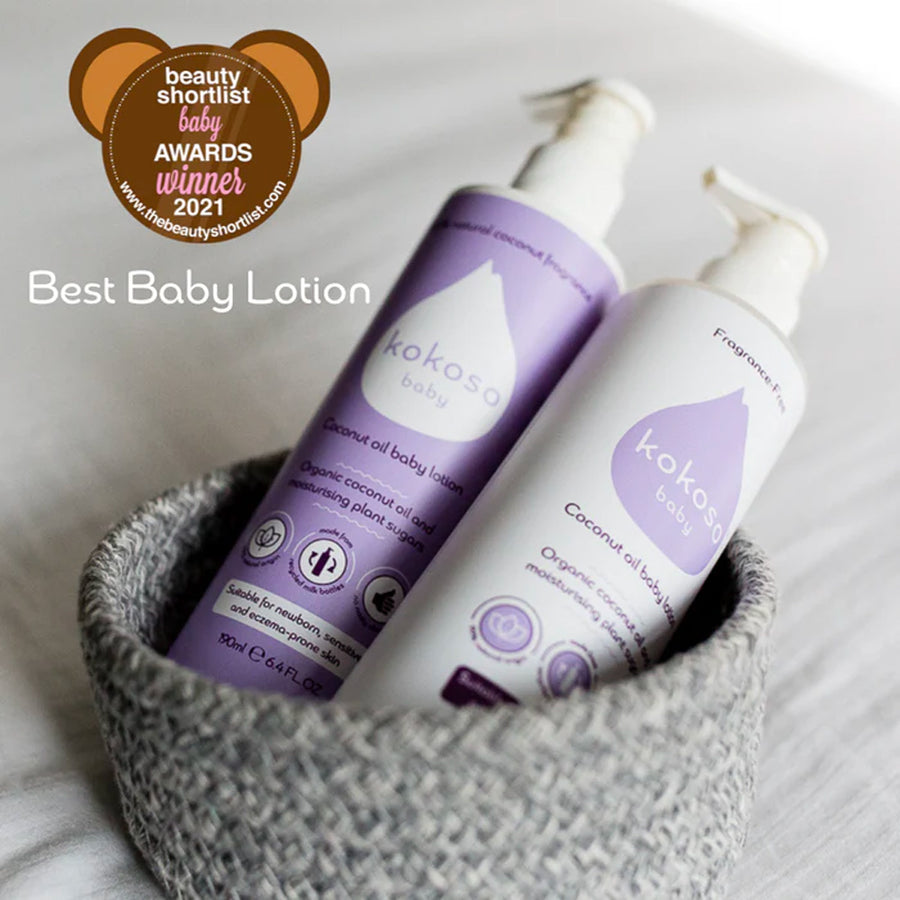 Kokoso coconut oil baby lotion bottles in a grey woven basket next to an award sticker for the Baby Awards 2021