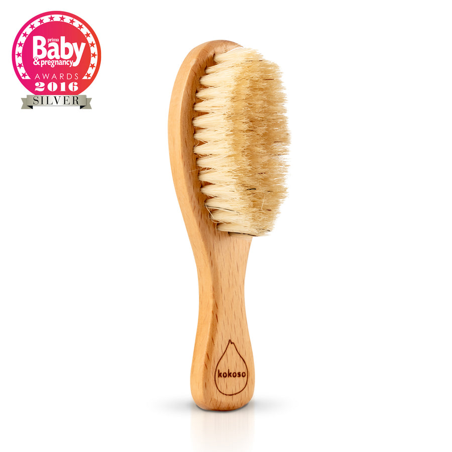 Kokoso small wooden baby hairbrush on a white background next to the Prima Baby & Pregnancy Awards stamp