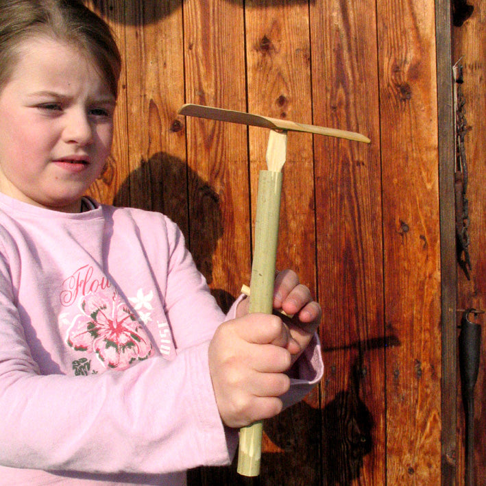 Child pulling a string on the Kraul Super Bamboo Dragonfly.