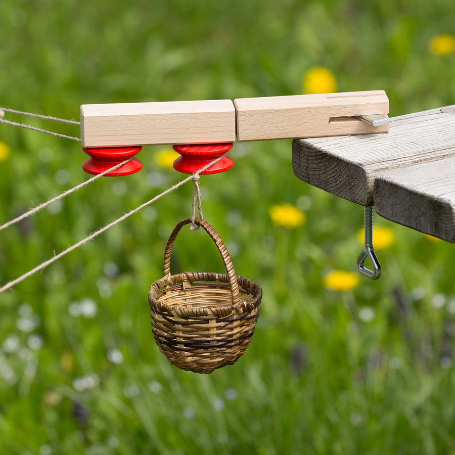 Two small dolls in a wicker basket cable car