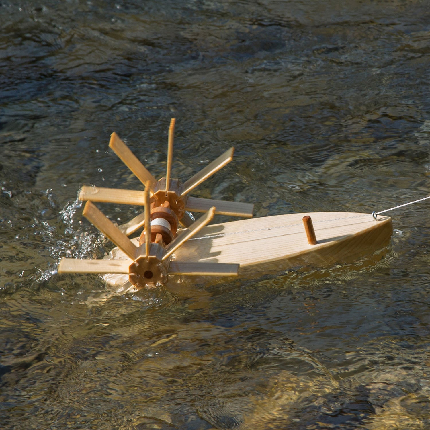 Kraul Trout Paddle Boat being pulled with string on the water.