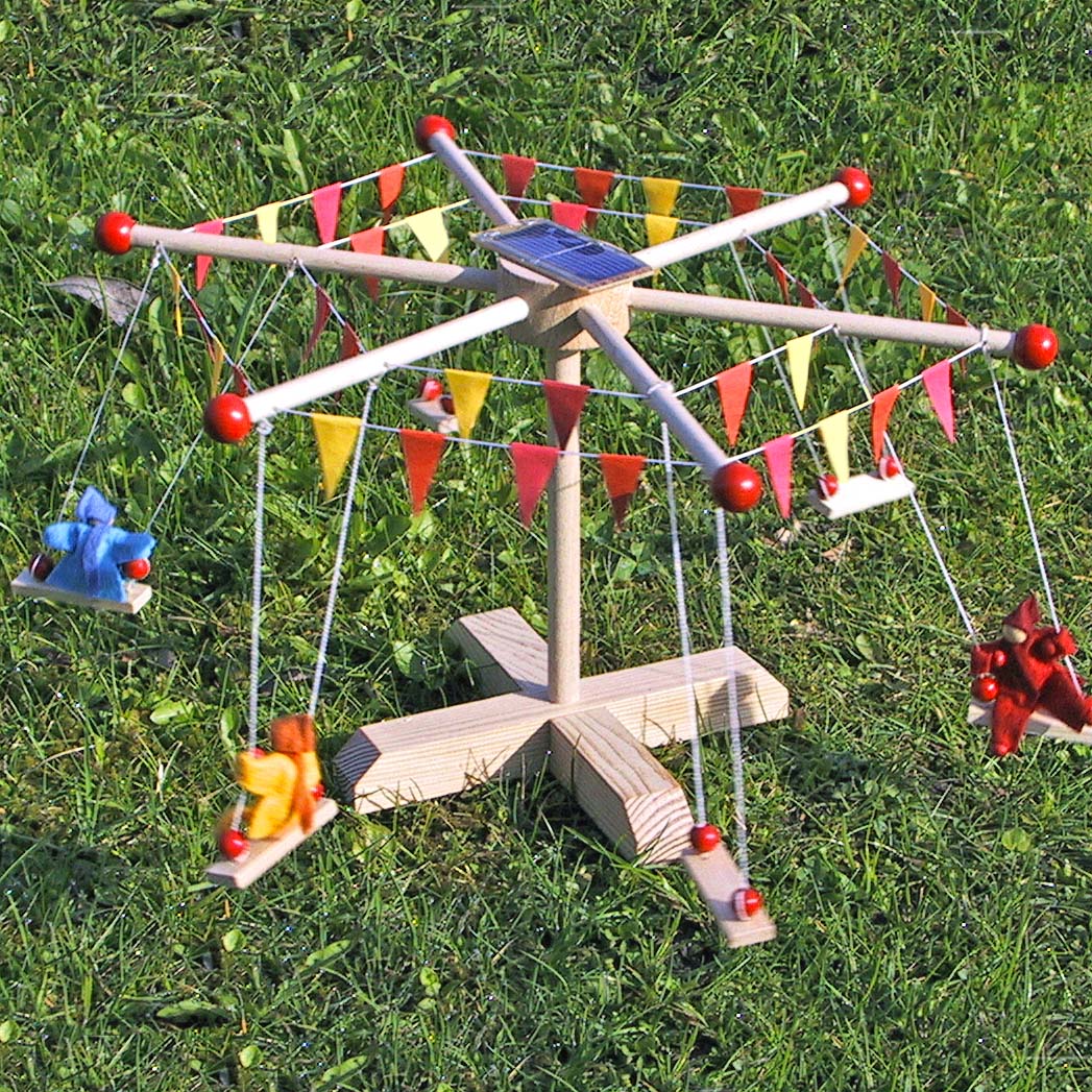 Kraul Solar Carousel construction kit with passenger dolls on carousel swings