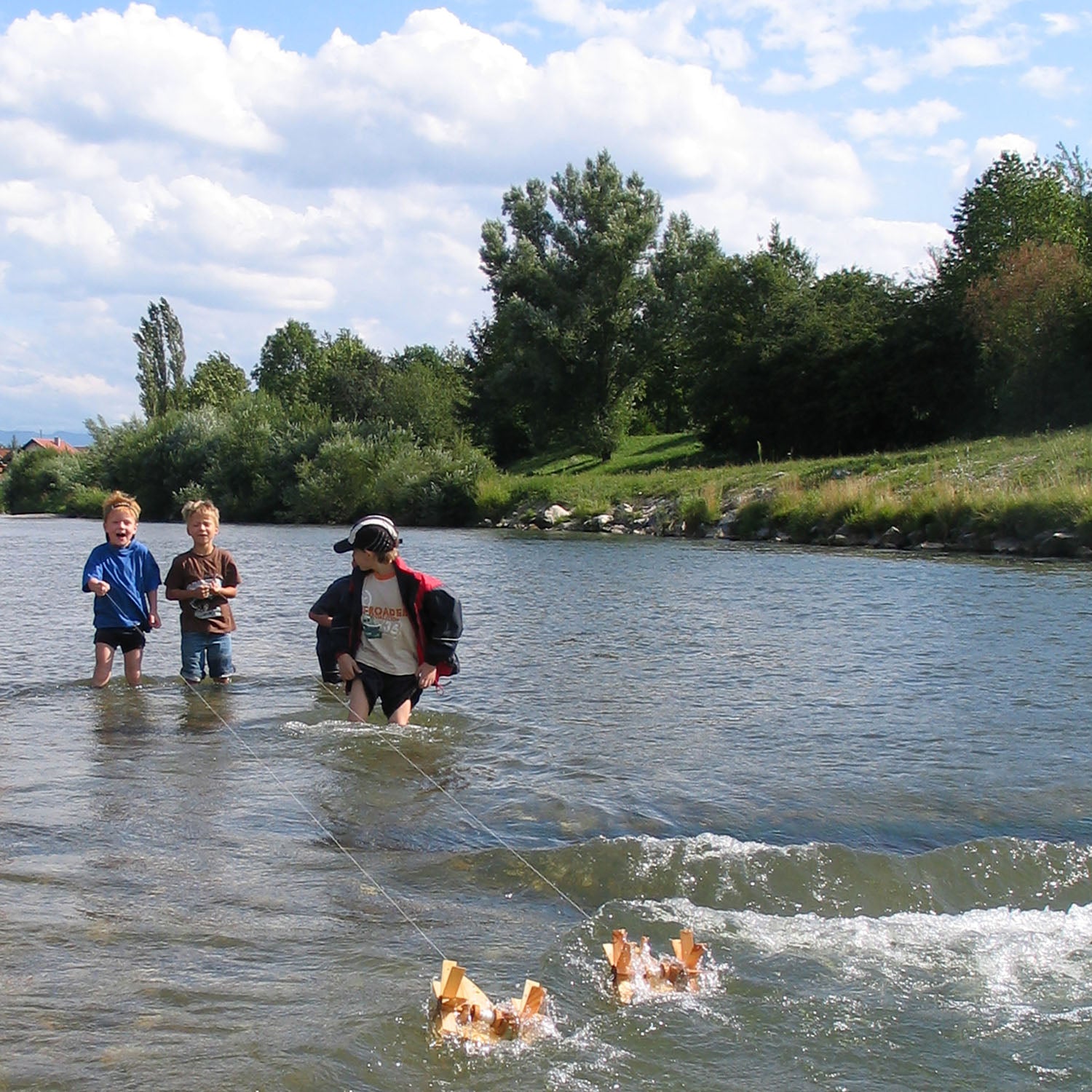 Three children playing on the river