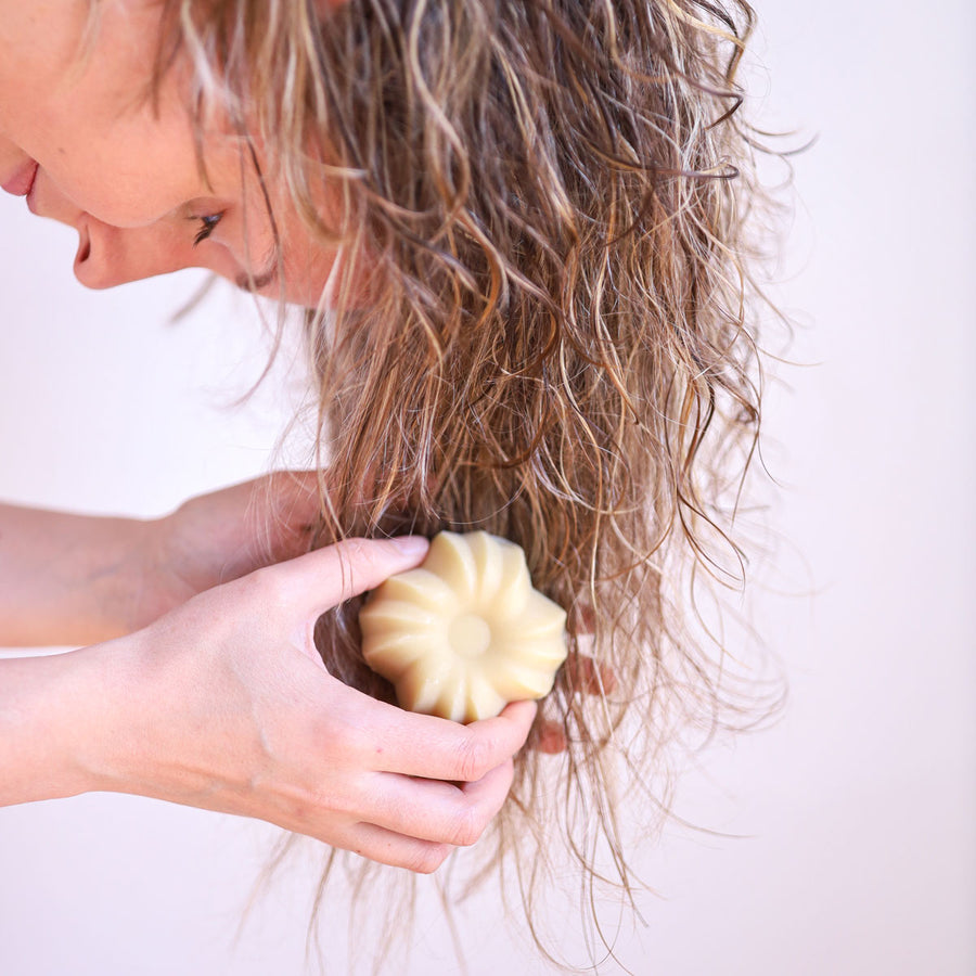 Person washing hair with the Lamazuna Detangling & Nourishing Solid Conditioner Bar