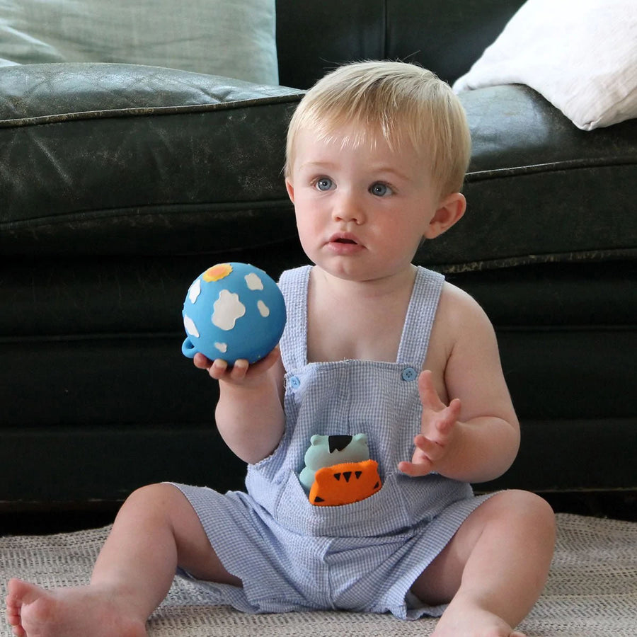 Young child holding the the Lanco day and night moulded natural rubber ball toy