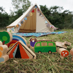 Close up of the Babipur Lanka Kade dan y ser wooden toy set on a grass background in front of a beige tent