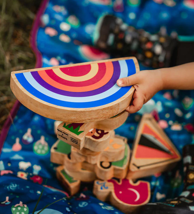 A close up of hand grabbing the Lanka Kade Babipur Machlud Haul Sunset toy on top of a stack of Lanka Kade dan y ser figures.