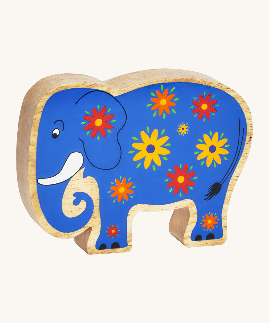 A blue wooden Lanka Kade elephant with yellow and red flowers on a cream background.