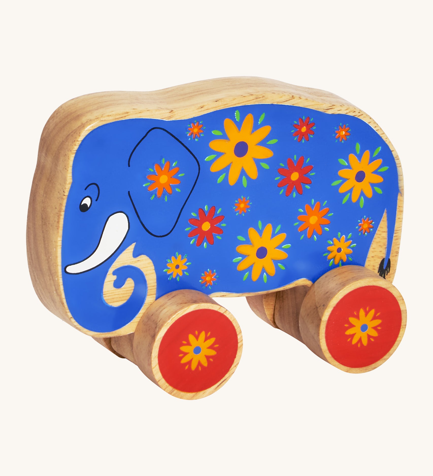 A blue wooden Lanka Kade push along elephant with yellow and red flowers with red wheels on a cream background.