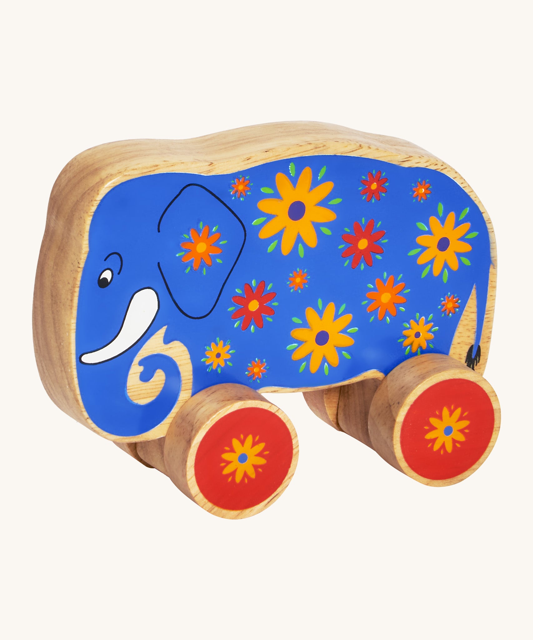 A blue wooden Lanka Kade push along elephant with yellow and red flowers with red wheels on a cream background.