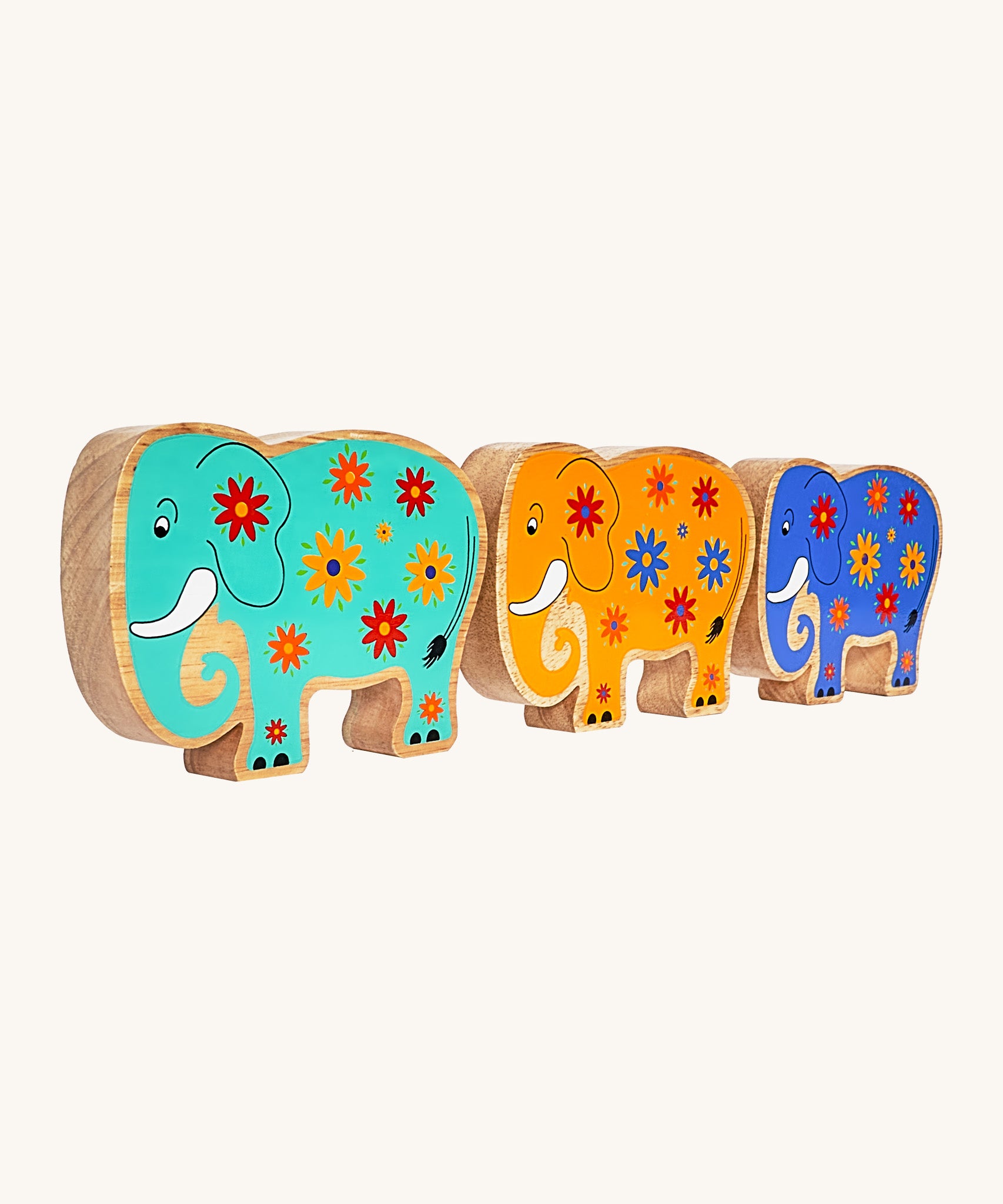 A side angle of the green, yellow and blue wooden Lanka Kade elephants on a cream background.