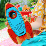 Close up of a child holding the Lanka Kade wooden toy rocket