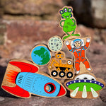 Close up of the Lanka Kade plastic-free wooden space toys in a stack on a rock