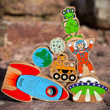 Close up of the Lanka Kade plastic-free wooden space toys in a stack on a rock