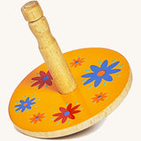 A yellow wooden Lanka Kade spinning top with red and blue flowers on a cream background.